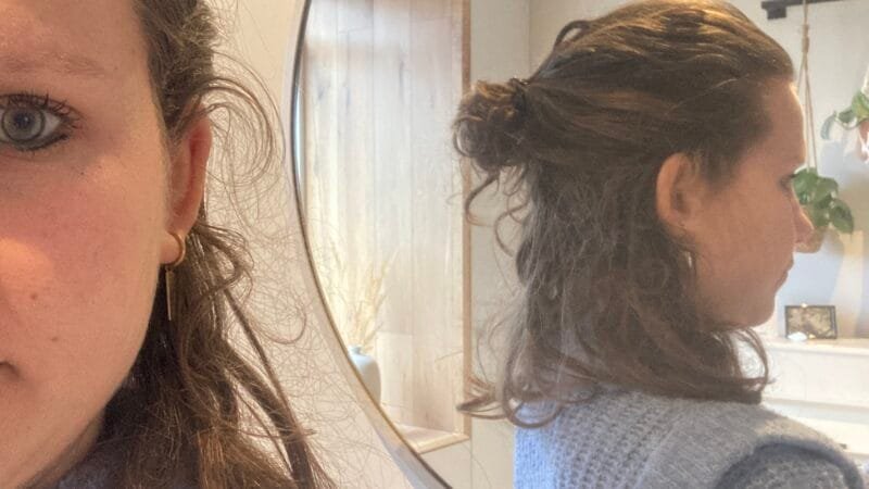 Vrouw kijkt in de spiegel tijdens reflectie over verbinding in relaties en het loslaten van het perfecte huwelijk.